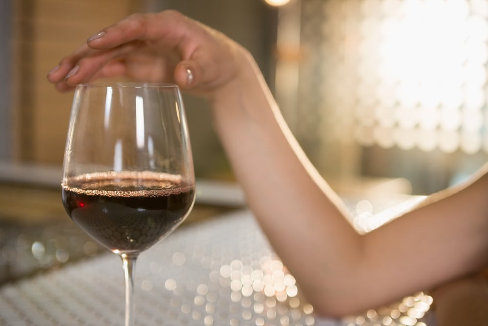 Woman having red wine at bar counter in bar